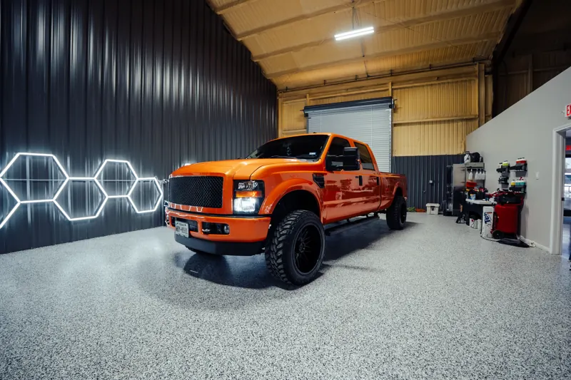 Wide shot of the orange F-350 inside the shop