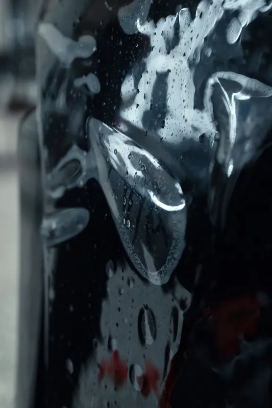 Macro shot of squeegee and slip solution on dark film
