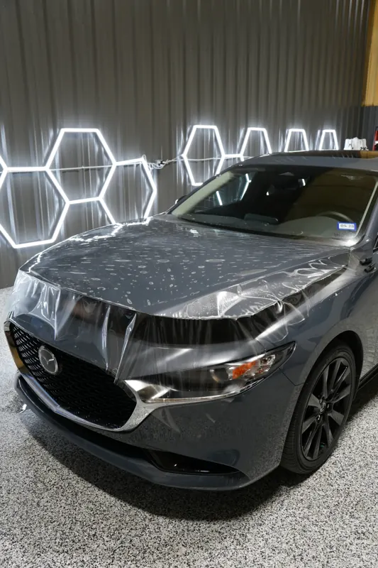 Paint protection film laid over a Mazda3 hood mid-install