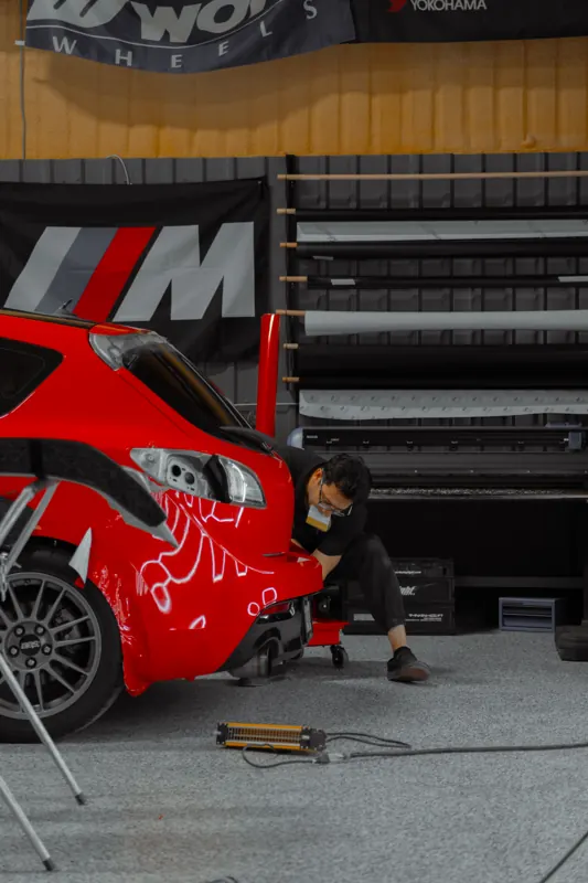 Installer working the Mazdaspeed3 rear bumper