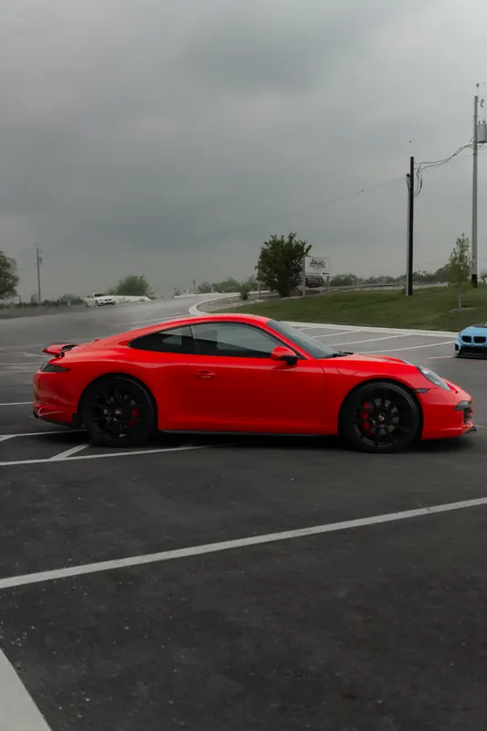 Red Porsche 911 side profile in the parking lot